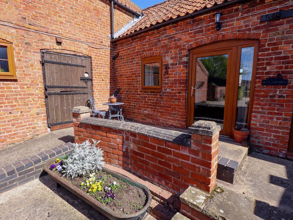 An outdoor area with a brick wall and a wooden door at Ticklepenny in Louth