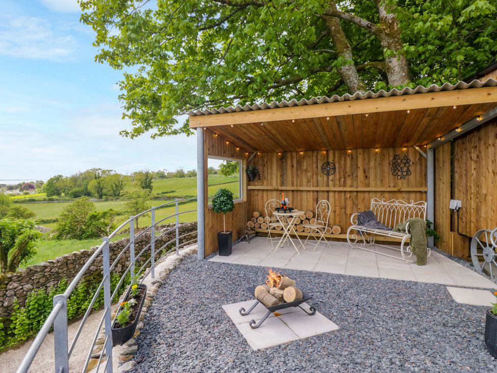 An outdoor seating area with a table and fire pit at Little Hut in Grange-Over-Sands
