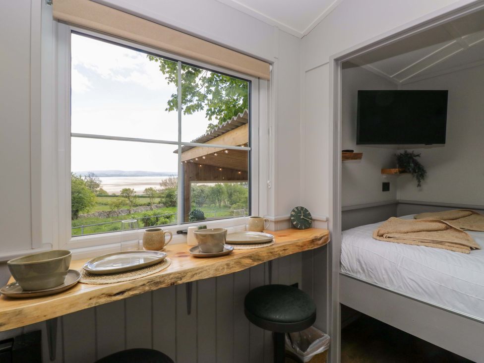A bedroom with a view and dining area at Little Hut Grange-Over-Sands