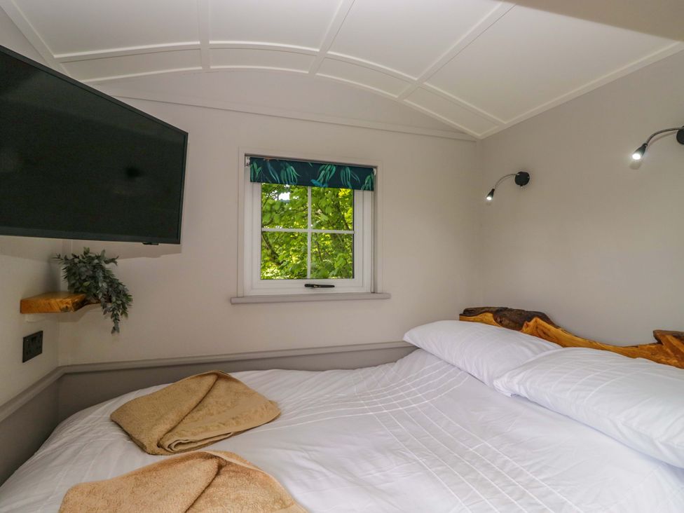 A bedroom with a bed and a television at Little Hut in Grange-Over-Sands