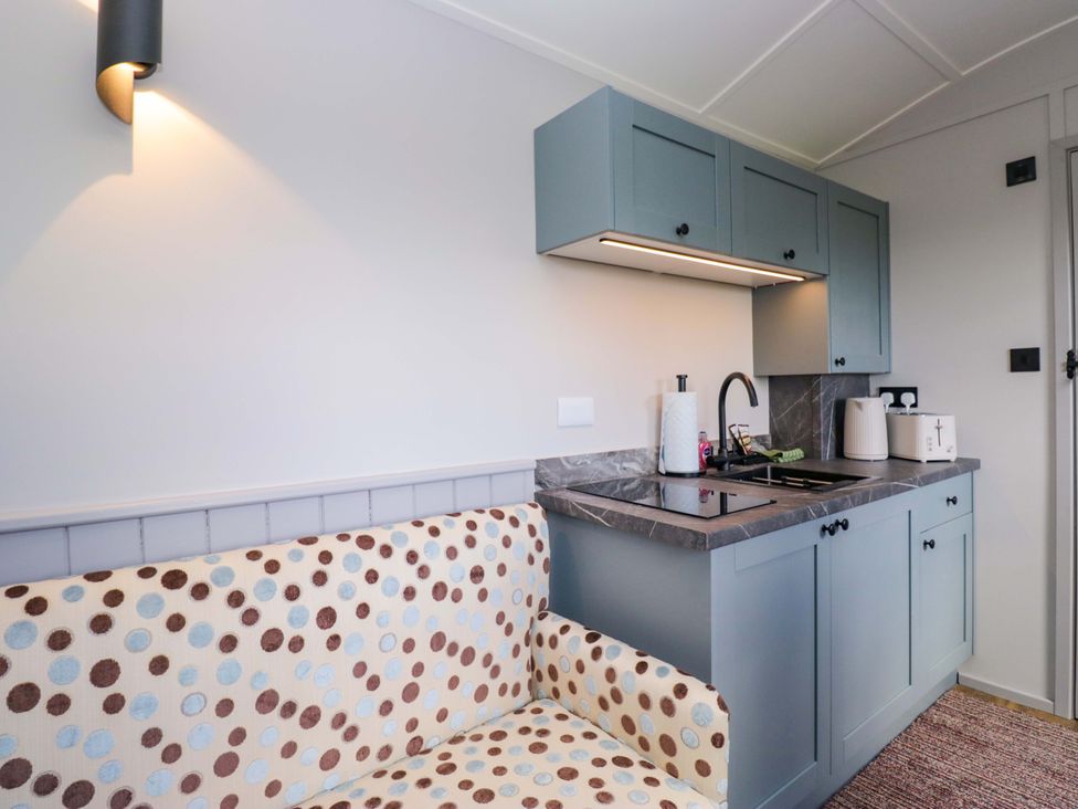 A kitchen with a sink and stove at Little Hut in Grange-Over-Sands
