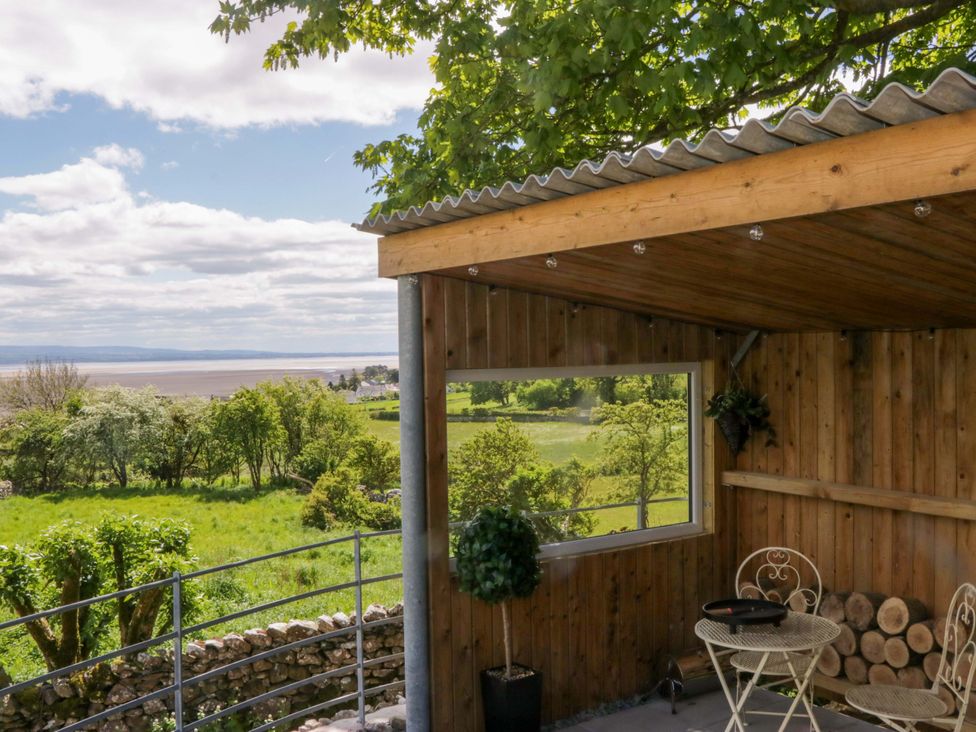 An outdoor seating area with a table and chairs at Little Hut in Grange-Over-Sands