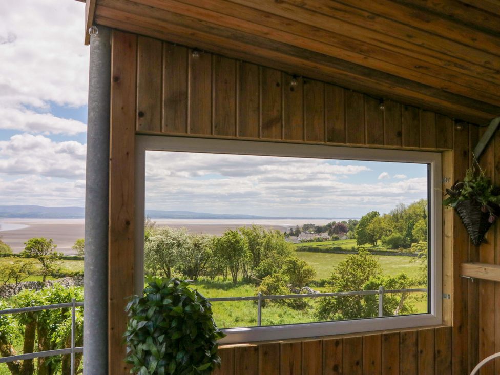 A view from a window showing greenery and a river at Little Hut in Grange-Over-Sands