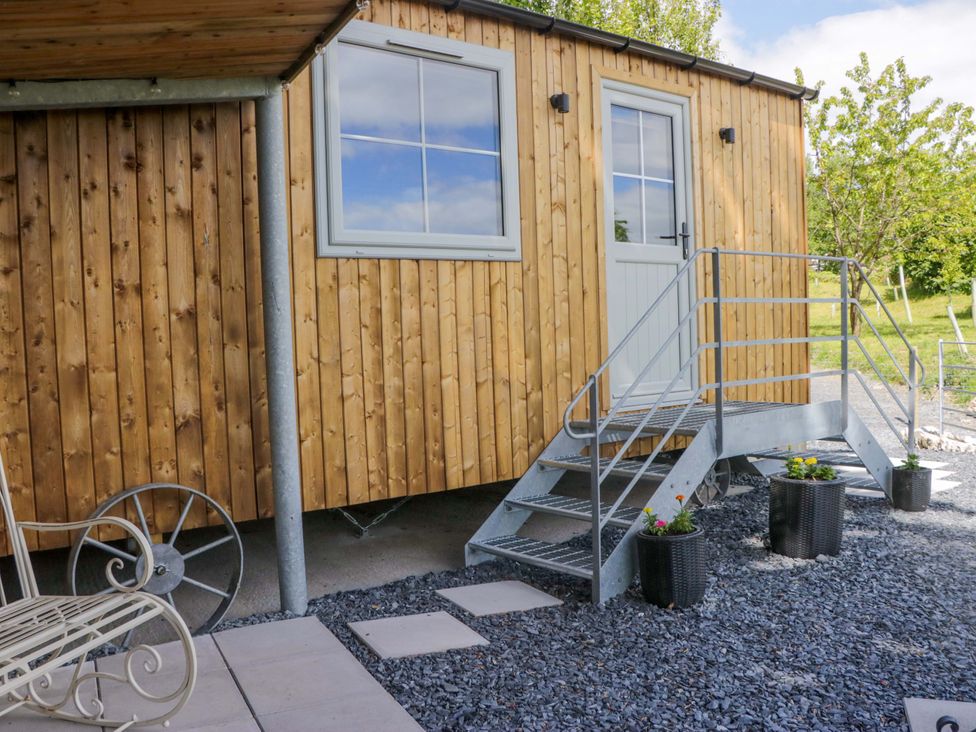 A wooden structure with a door and staircase at Little Hut Grange-Over-Sands