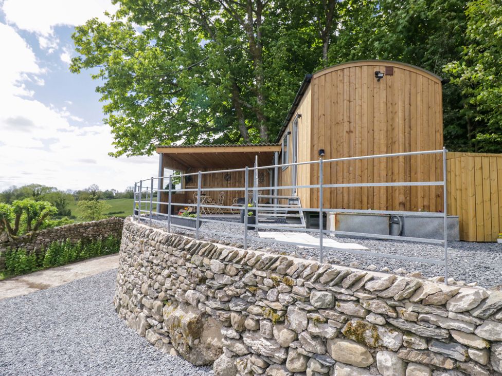 A wooden cabin with gravel and stone wall at Little Hut in Grange-Over-Sands
