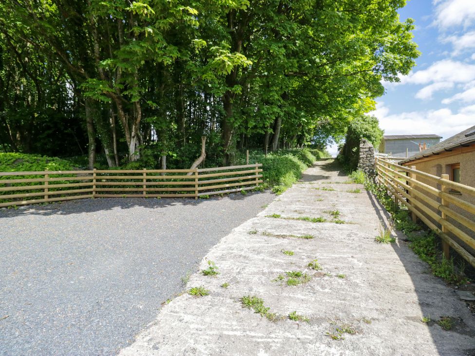 A pathway with trees and a fence at Little Hut in Grange-Over-Sands