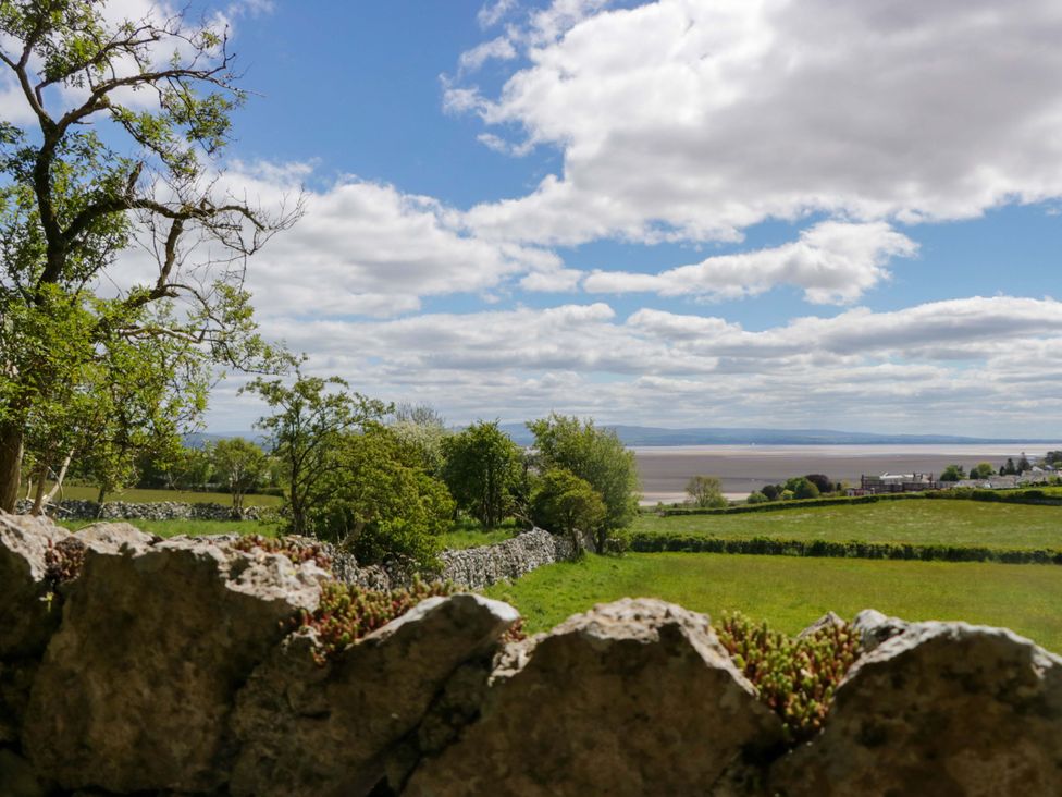 A view of a landscape with stone wall and trees at Little Hut in Grange-Over-Sands