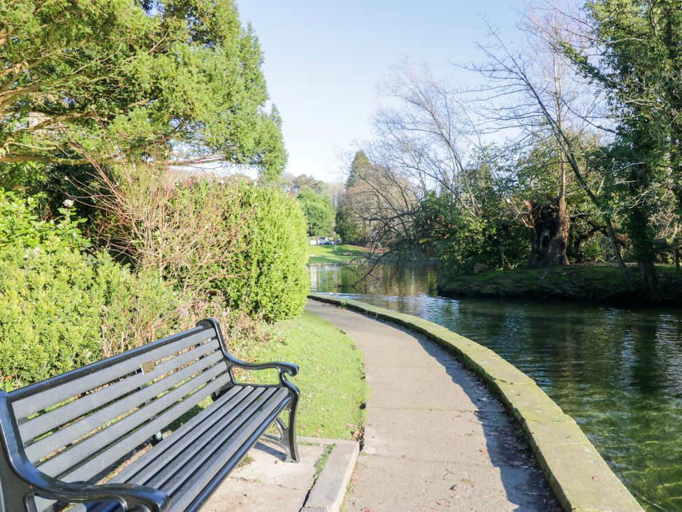 A pathway beside a stream with a bench at Little Hut in Grange-Over-Sands