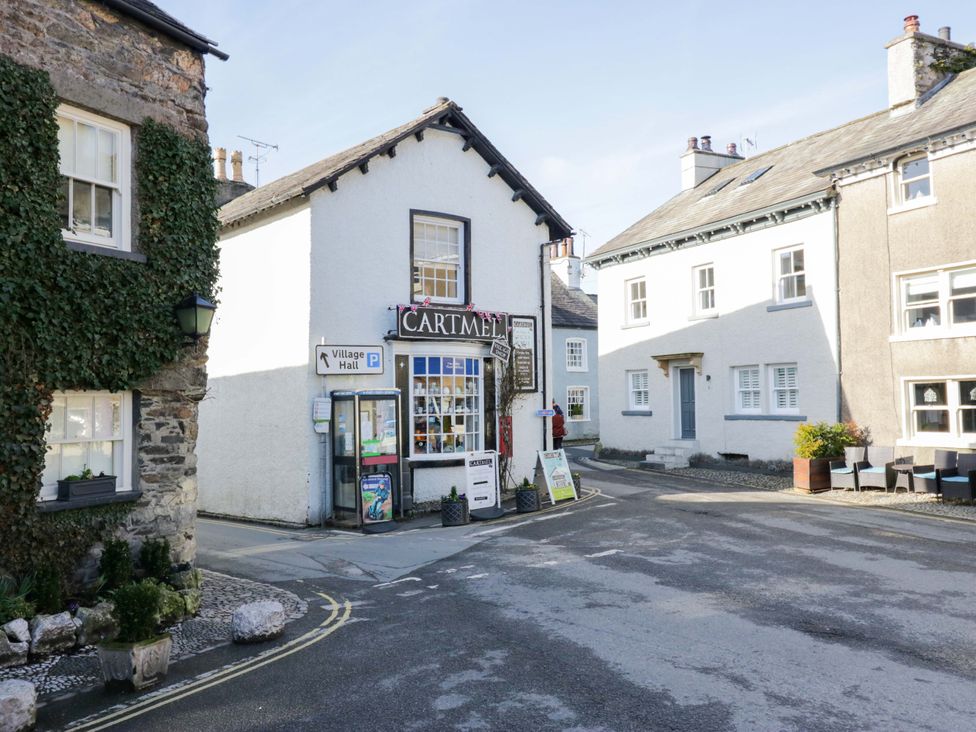 A corner building with a sign for CARTMEL and a telephone booth at Little Hut in Grange-Over-Sands
