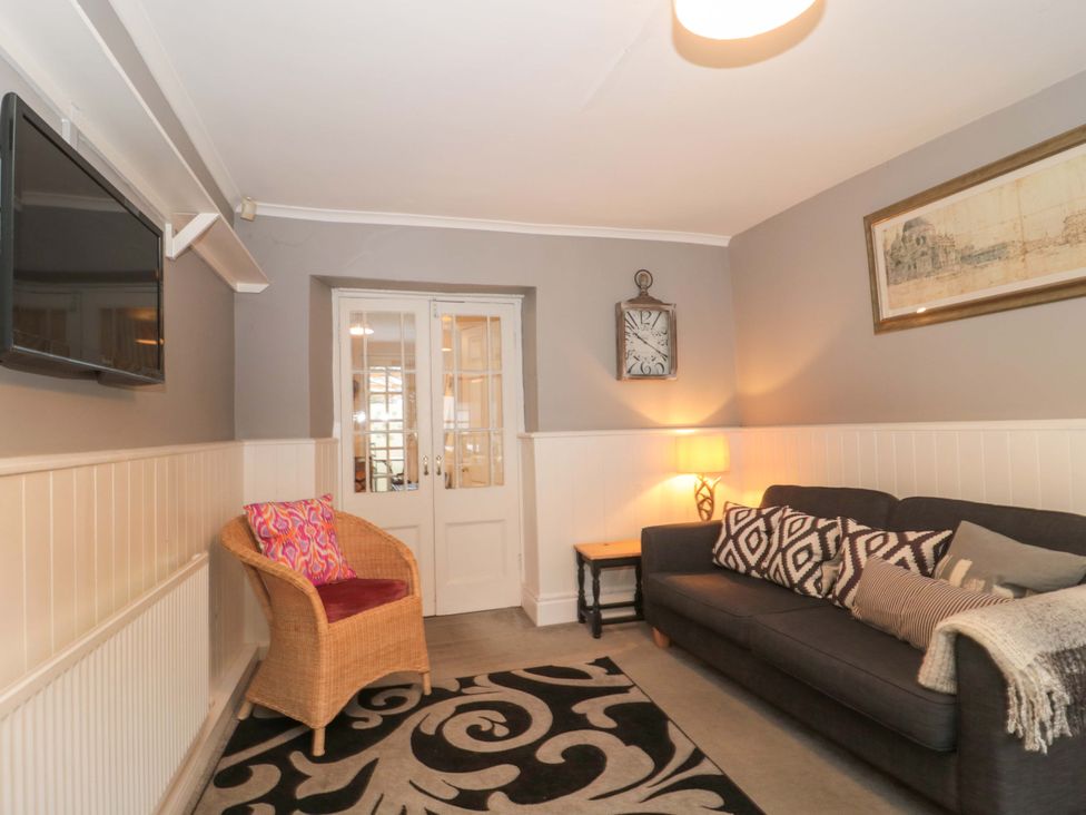 A living room with a sofa and a television at Stones Bakery in Wedmore