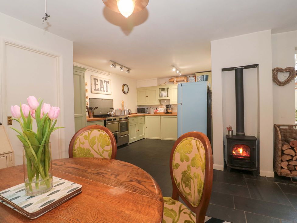 A kitchen featuring a table and chairs with a stove at Stones Bakery in Wedmore