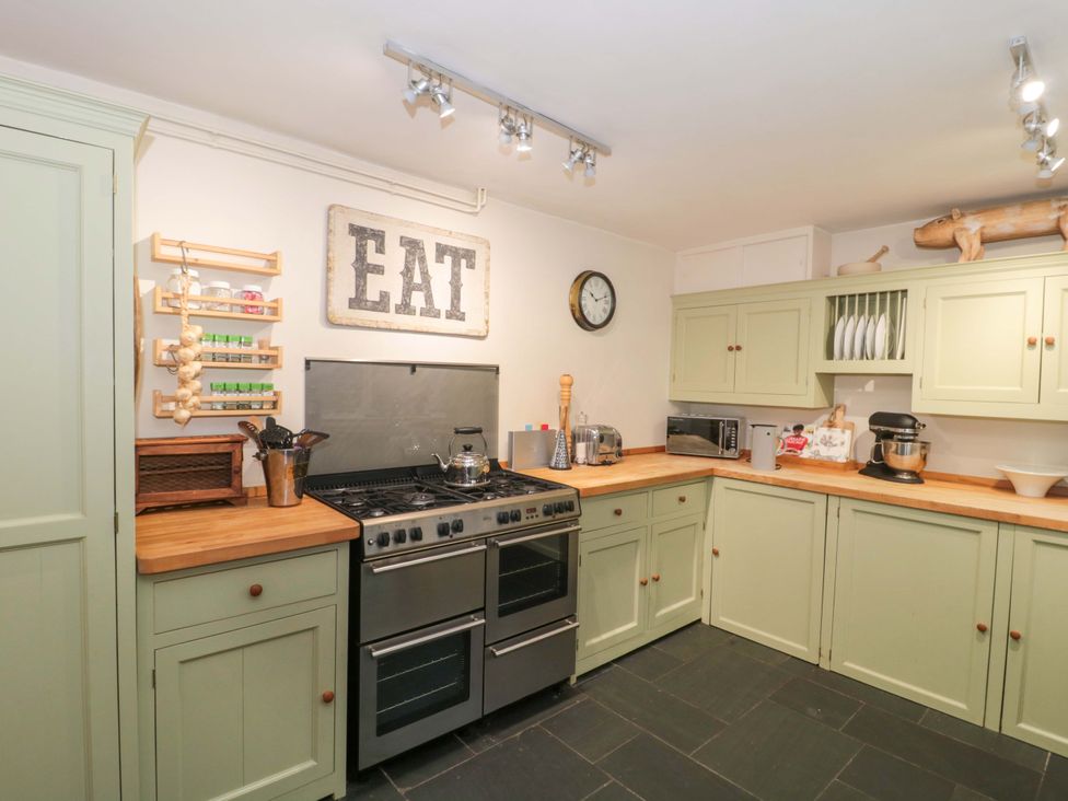 A kitchen with cabinets and an oven at Stones Bakery in Wedmore