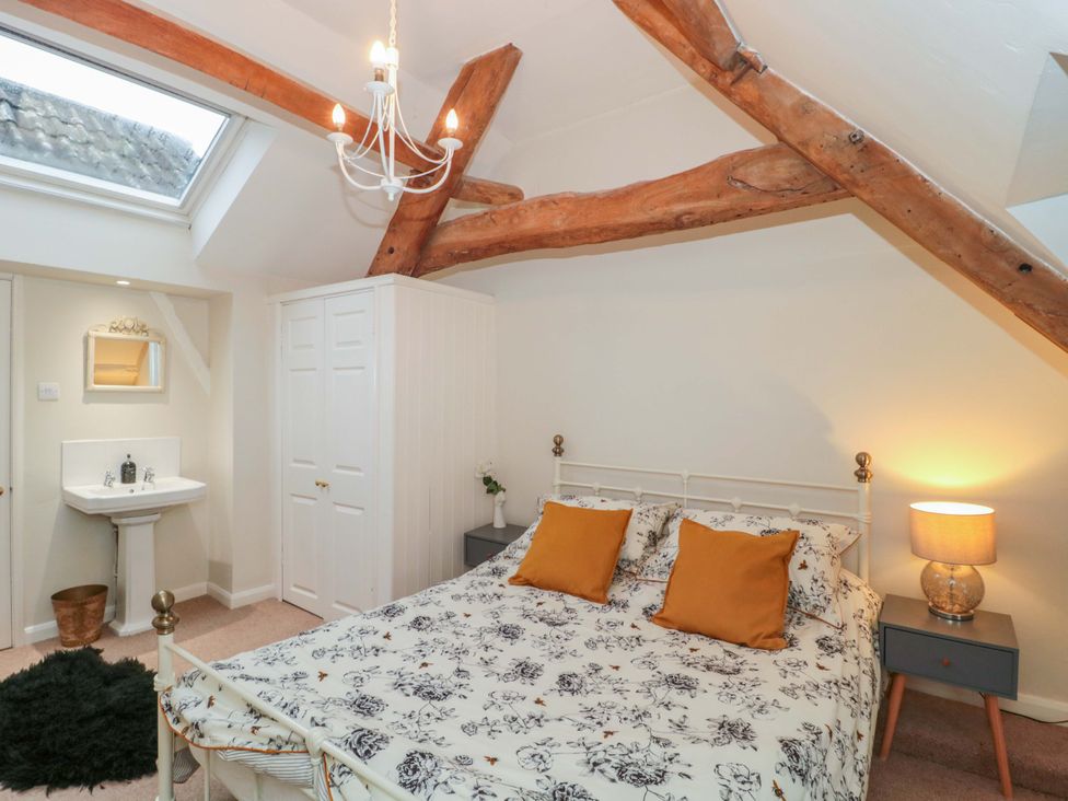 A bedroom with a bed and washbasin at Stones Bakery in Wedmore
