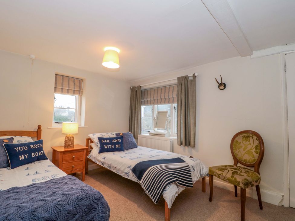 A bedroom with two beds and a window at Stones Bakery in Wedmore