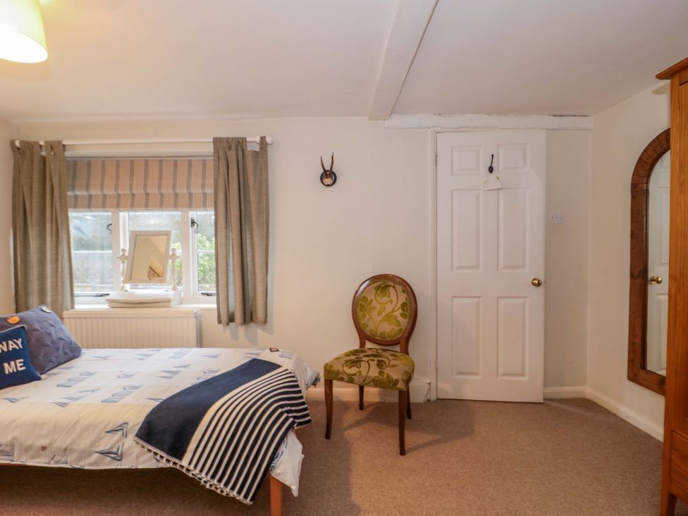 A bedroom with a bed and a chair at Stones Bakery in Wedmore