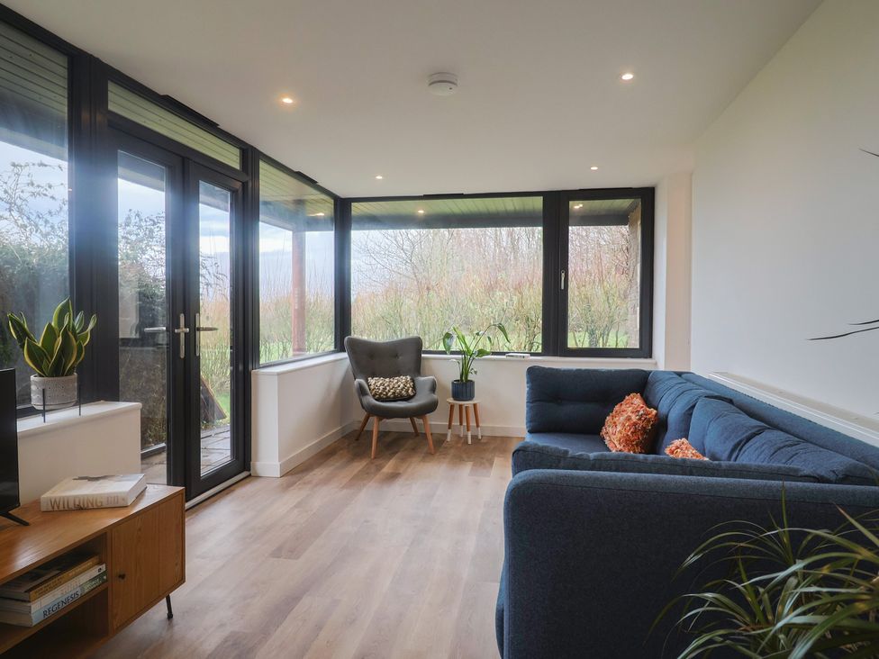 A snug with seating and windows at Little Poppes Lawn in Holditch near Hawkchurch