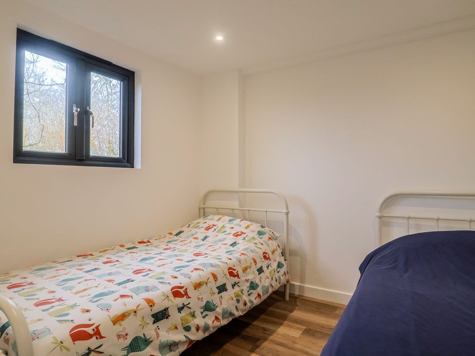 A bedroom with two beds and a window at Little Poppes Lawn in Holditch near Hawkchurch