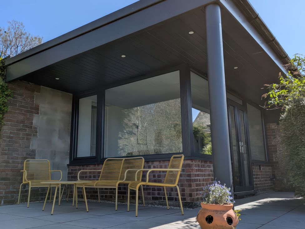 An outdoor seating area with chairs and a potted plant at Little Poppes Lawn, Holditch near Hawkchurch