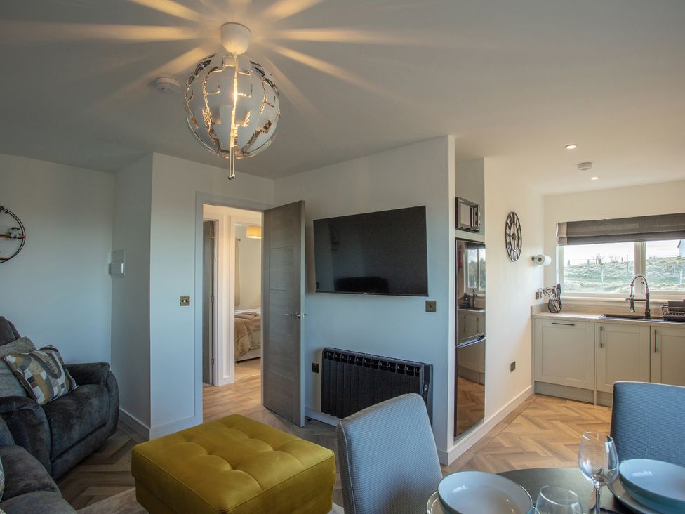A living room with a sofa and television at 365 South Boisdale, Daliburgh, Isle Of South Uist