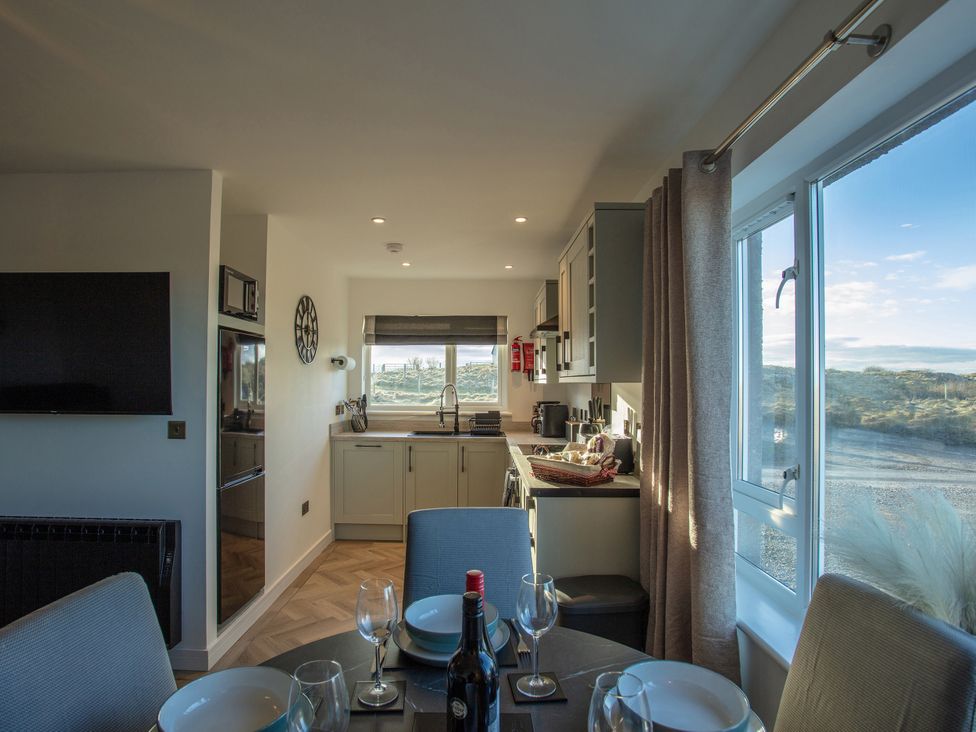 A kitchen with a dining area featuring a table and chairs at 365 South Boisdale, Daliburgh, Isle Of South Uist