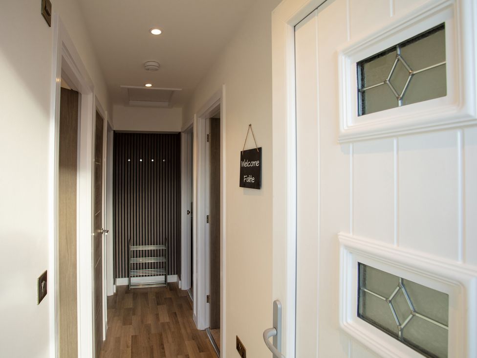 A hallway with a welcome sign and coat rack at 365 South Boisdale, Daliburgh, Isle Of South Uist