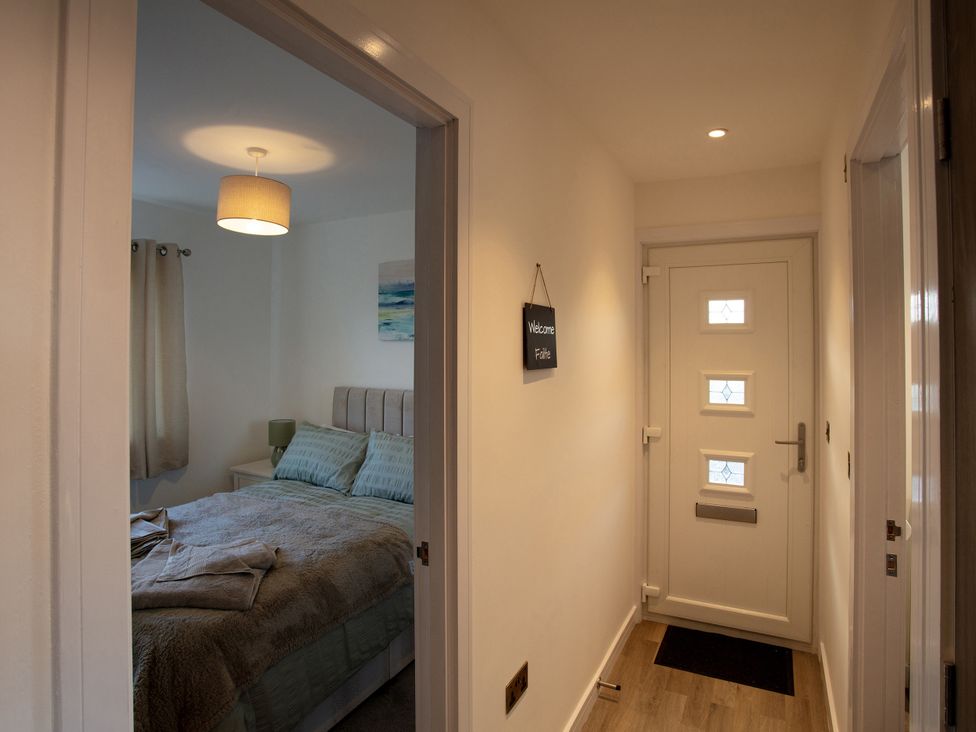 A hallway with a visible bedroom doorway and welcome sign at 365 South Boisdale, Daliburgh, Isle Of South Uist