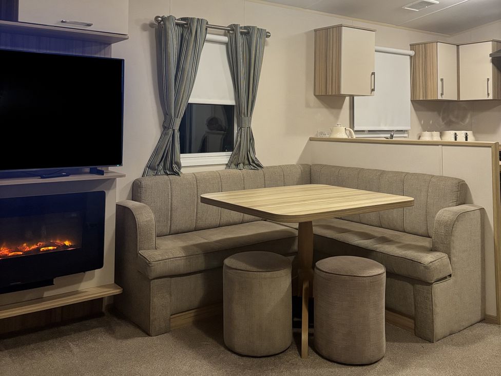 A dining area with a sofa and table at 169 Abergele