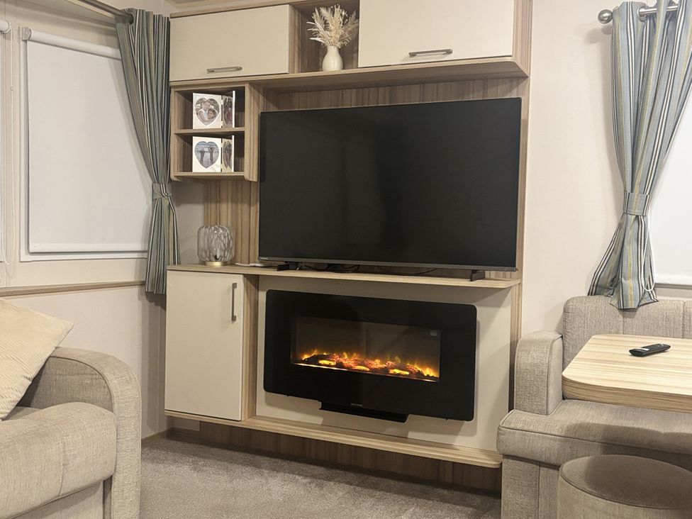 A living room with a television and fireplace at The Old Barn in Abergele