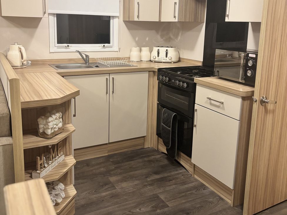 A kitchen with cooking appliances and storage at 169 Abergele