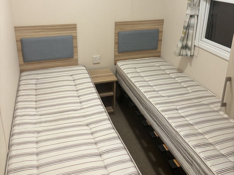 A bedroom with two single beds and a side table at 169 Abergele