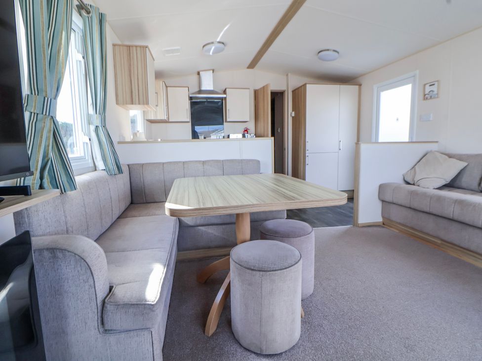 A living room with a dining table and sofa at St Michaels Caravan Park - 236 Towyn