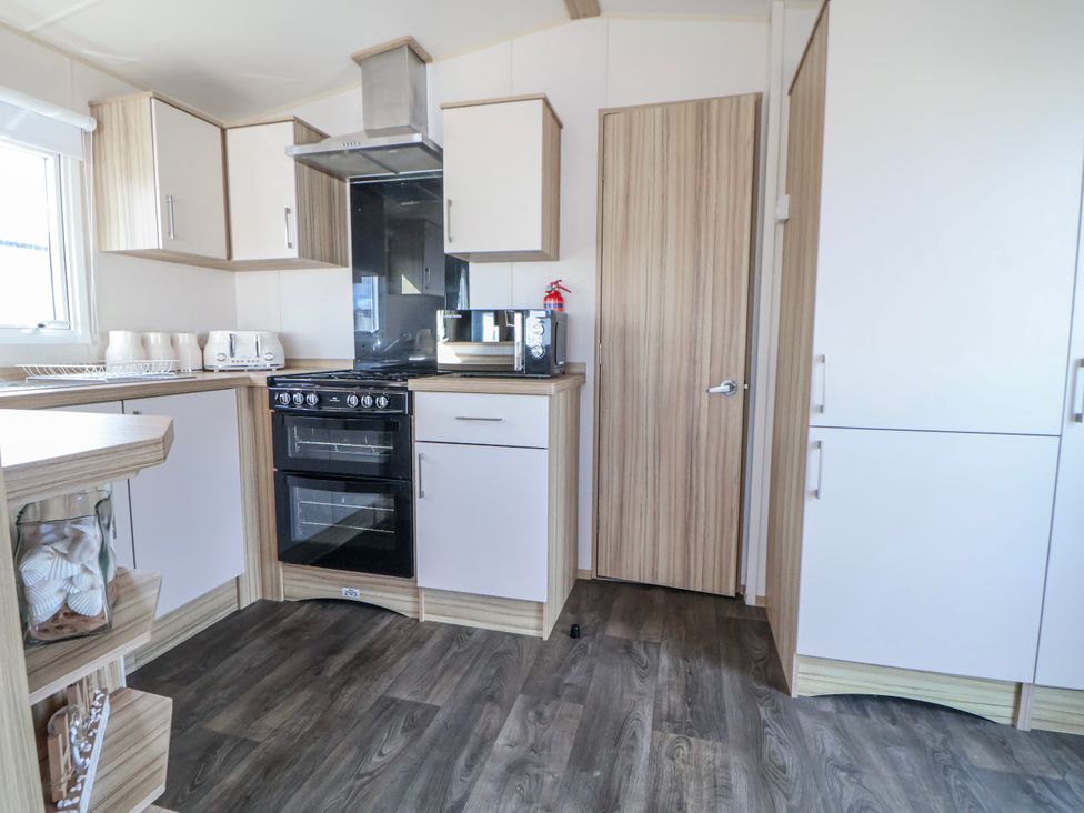 A kitchen with cabinets and appliances at St Michaels Caravan Park - 236 Towyn