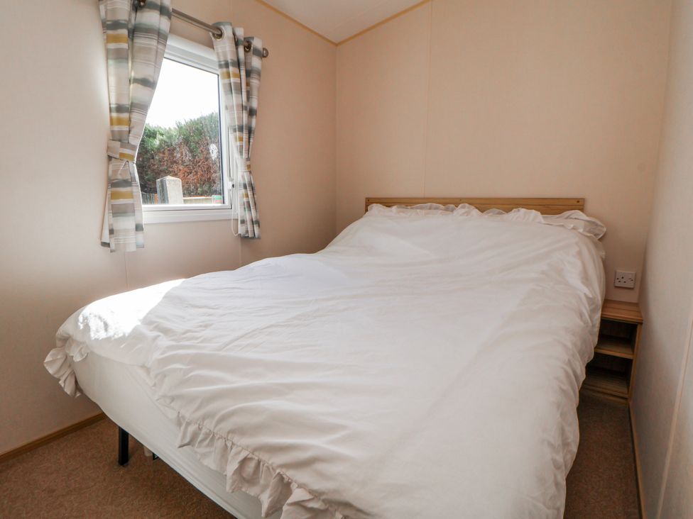 A bedroom with a bed and a window at St Michaels Caravan Park - 236 Towyn