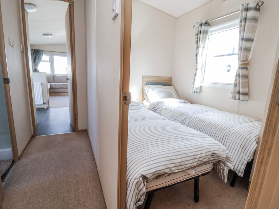 A bedroom with twin beds and a window at St Michaels Caravan Park - 236 Towyn