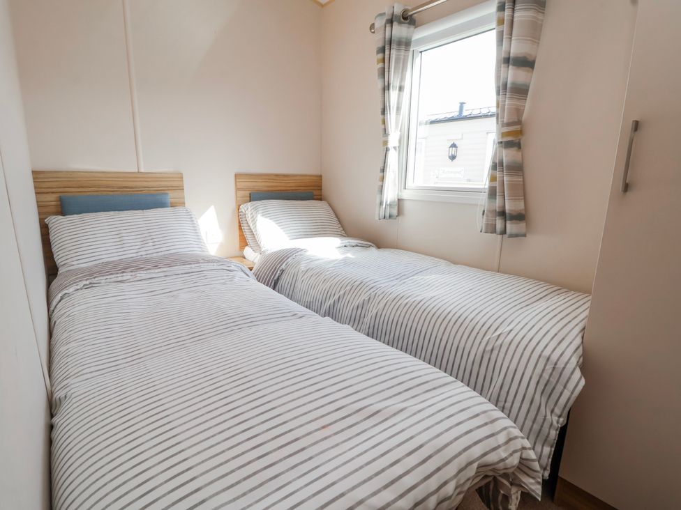 A bedroom with two beds and a window at St Michaels Caravan Park - 236 Towyn