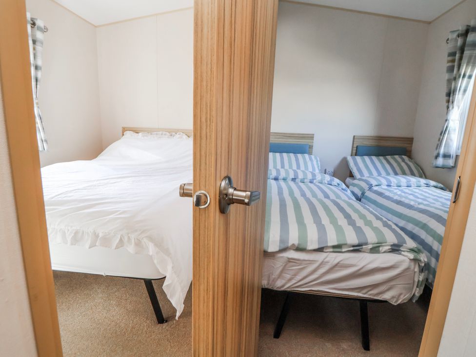 A bedroom with two beds at St Michaels Caravan Park - 236 Towyn