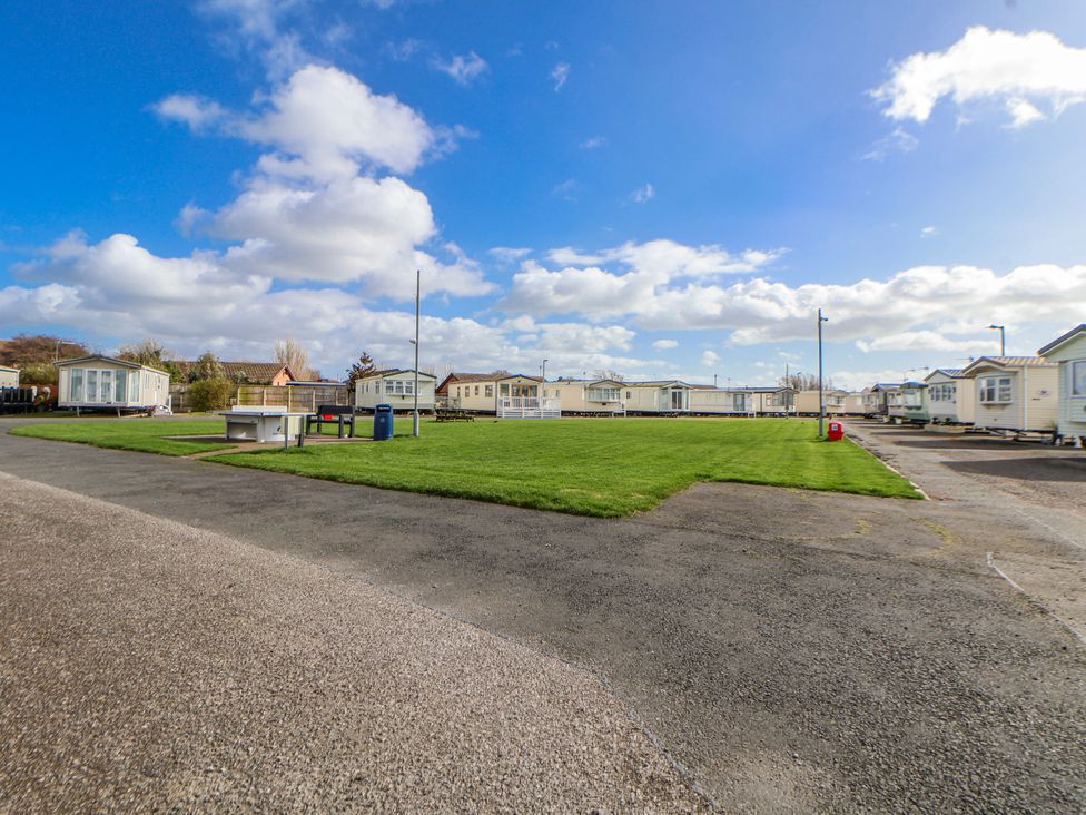 A park area with caravans and grass at St Michaels Caravan Park - 236 Towyn