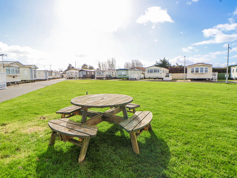 A picnic table in an outdoor area with caravans at St Michaels Caravan Park - 236 Towyn