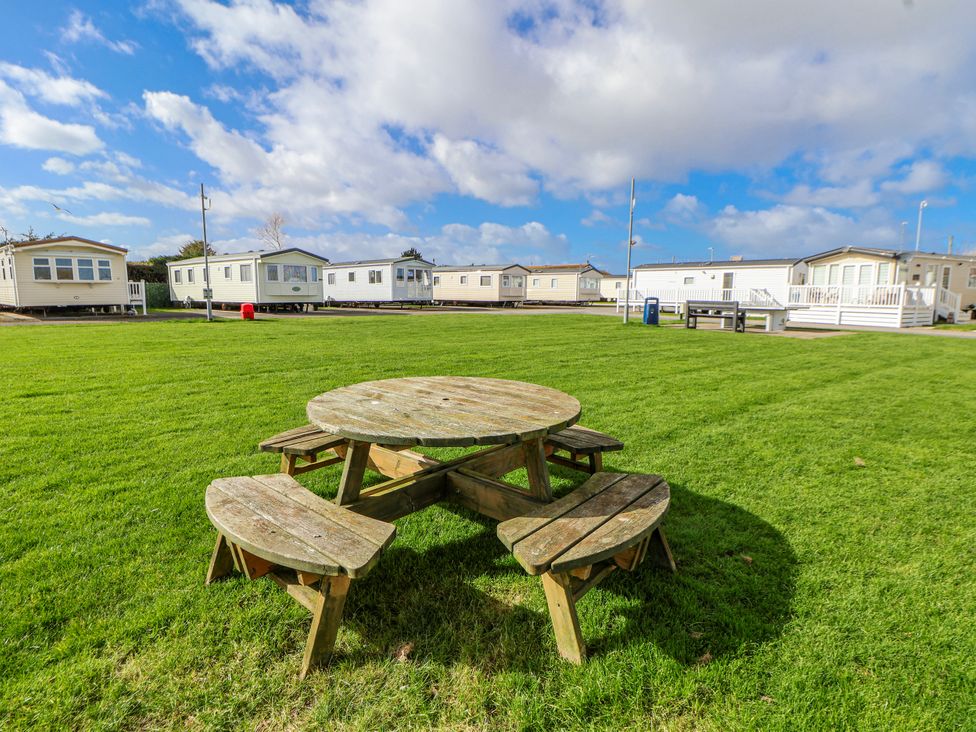 An outdoor area with a picnic table and caravans at St Michaels Caravan Park - 236 Towyn