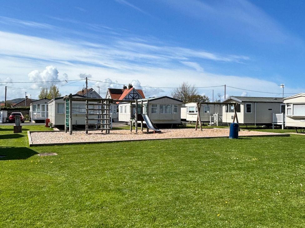 An outdoor area with playground equipment and caravans at The Beachside Hideout - St Michaels and Browns Caravan Park in Towyn