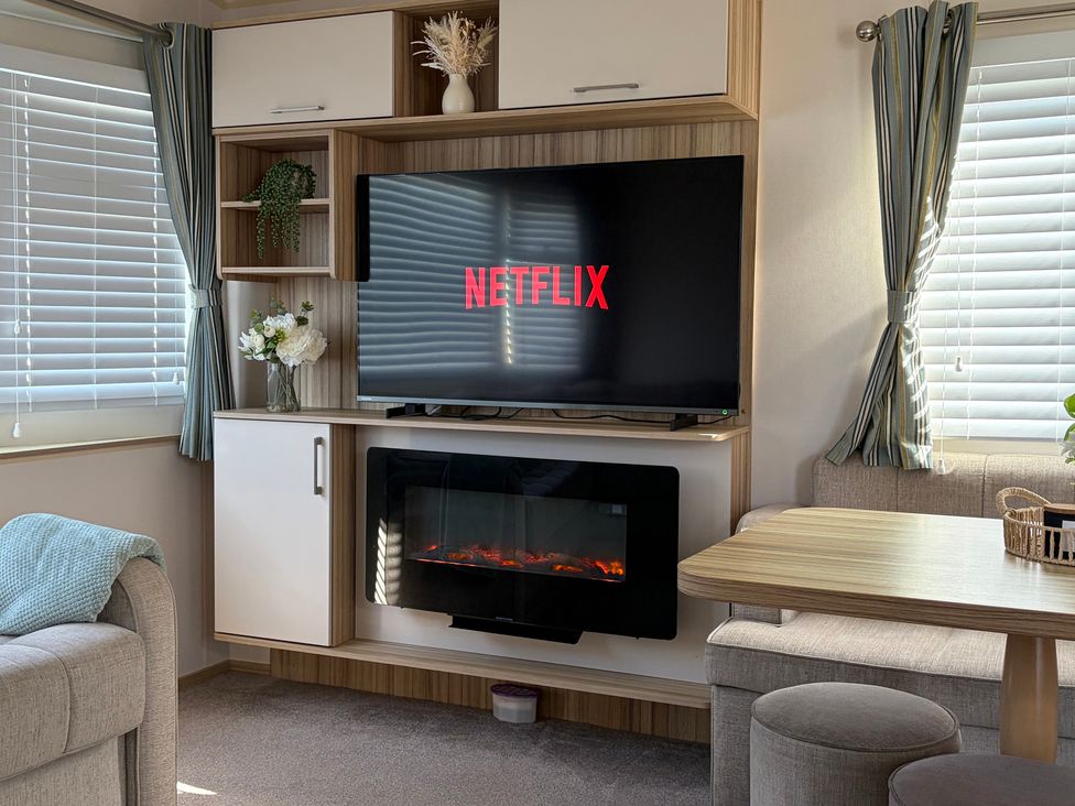 A living room with a television and fireplace at The Beachside Hideout - St Michaels Caravan Park Towyn