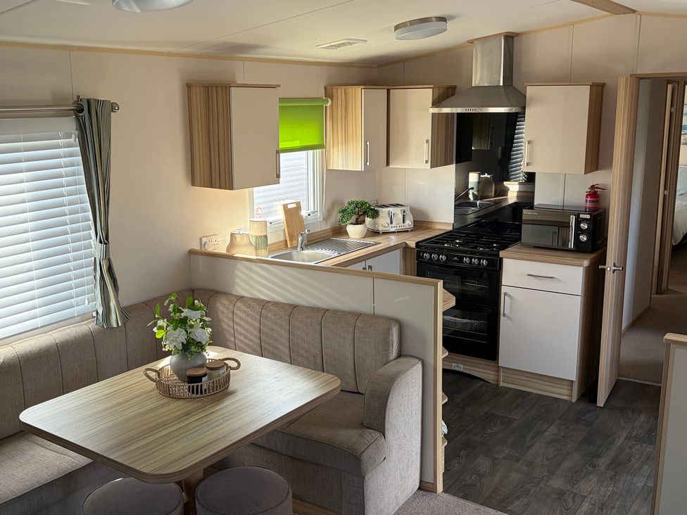 A kitchen with seating area at The Beachside Hideout - St Michaels Caravan Park in Towyn