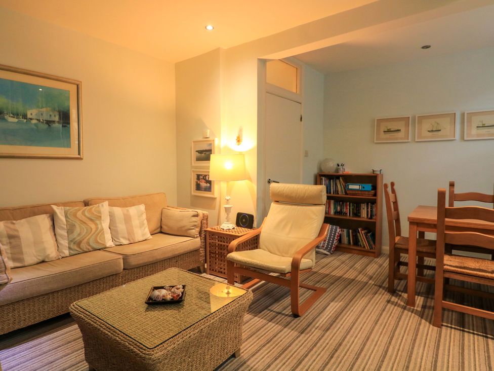 A living room with a sofa and dining table at Smugglers Cove in Dartmouth