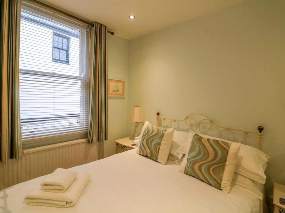 A bedroom with a bed and window at Smugglers Cove Dartmouth