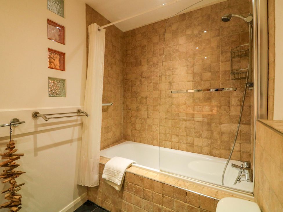 A bathroom with a bathtub and showerhead at Smugglers Cove in Dartmouth