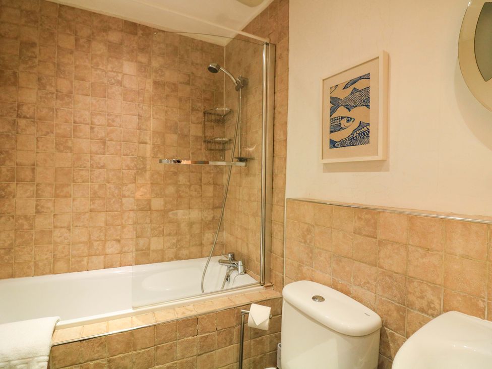 A bathroom with a bathtub, shower, and toilet at Smugglers Cove in Dartmouth