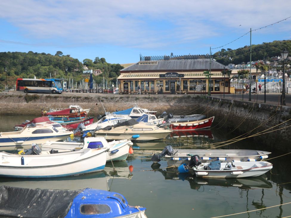 A harbor with boats and a restaurant at Smugglers Cove in Dartmouth