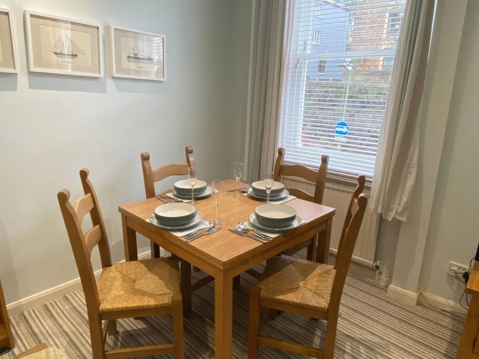 A dining room with a table and chairs at Snugglers Cove in Dartmouth