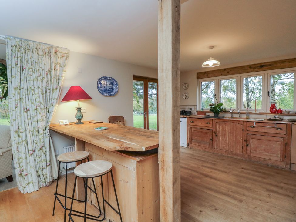 A kitchen with wooden bar counter and stools at Gardeners Hill Annex