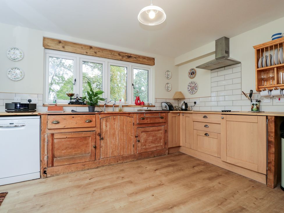 A kitchen with wooden cabinets and appliances at Gardeners Hill Annex